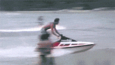 Gif of a man being thrown off of a beached jet ski