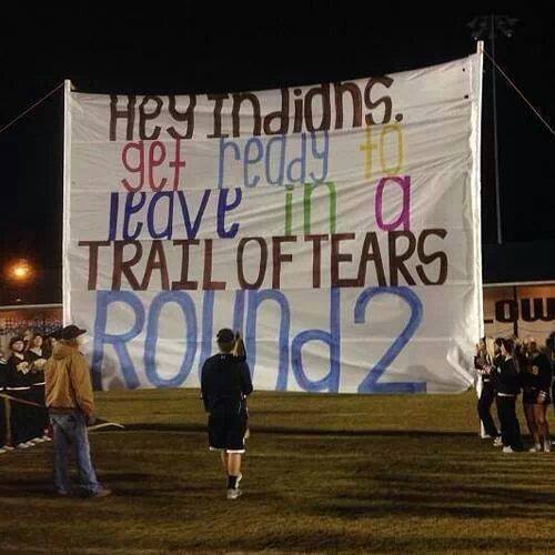 Banner reading "Hey Indians, get ready to leave in a trail of tears round 2" on a football field