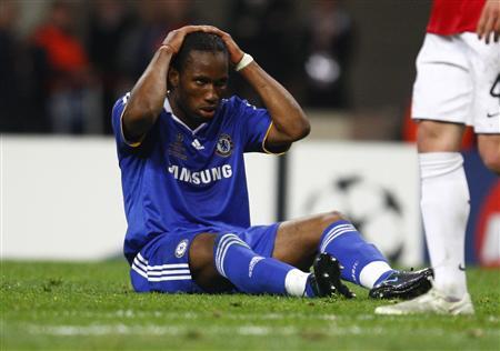 Didier Drogba sitting on the ground after being fouled.