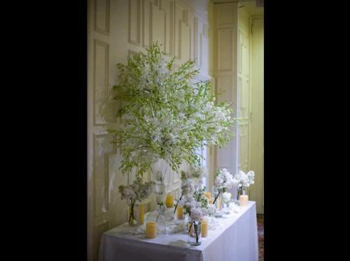 The centerpieces along the wedding aisle were elevated on tall bronze 