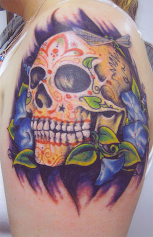 Here is a really cool and colorful sugar skull tattoo on the upper left arm