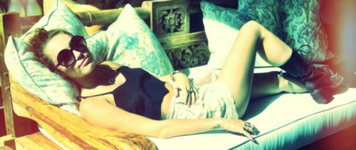 Miley Cyrus toma sol de bermudinha e barriga de fora