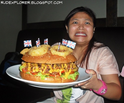 A workmate having a hard time holding the plate of the 12 Wheeler Burger. See the expression.