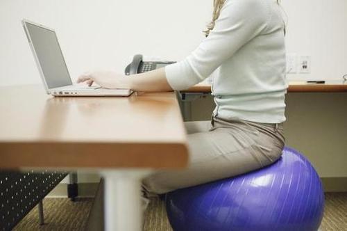 woman sitting on exercise ball in the office 